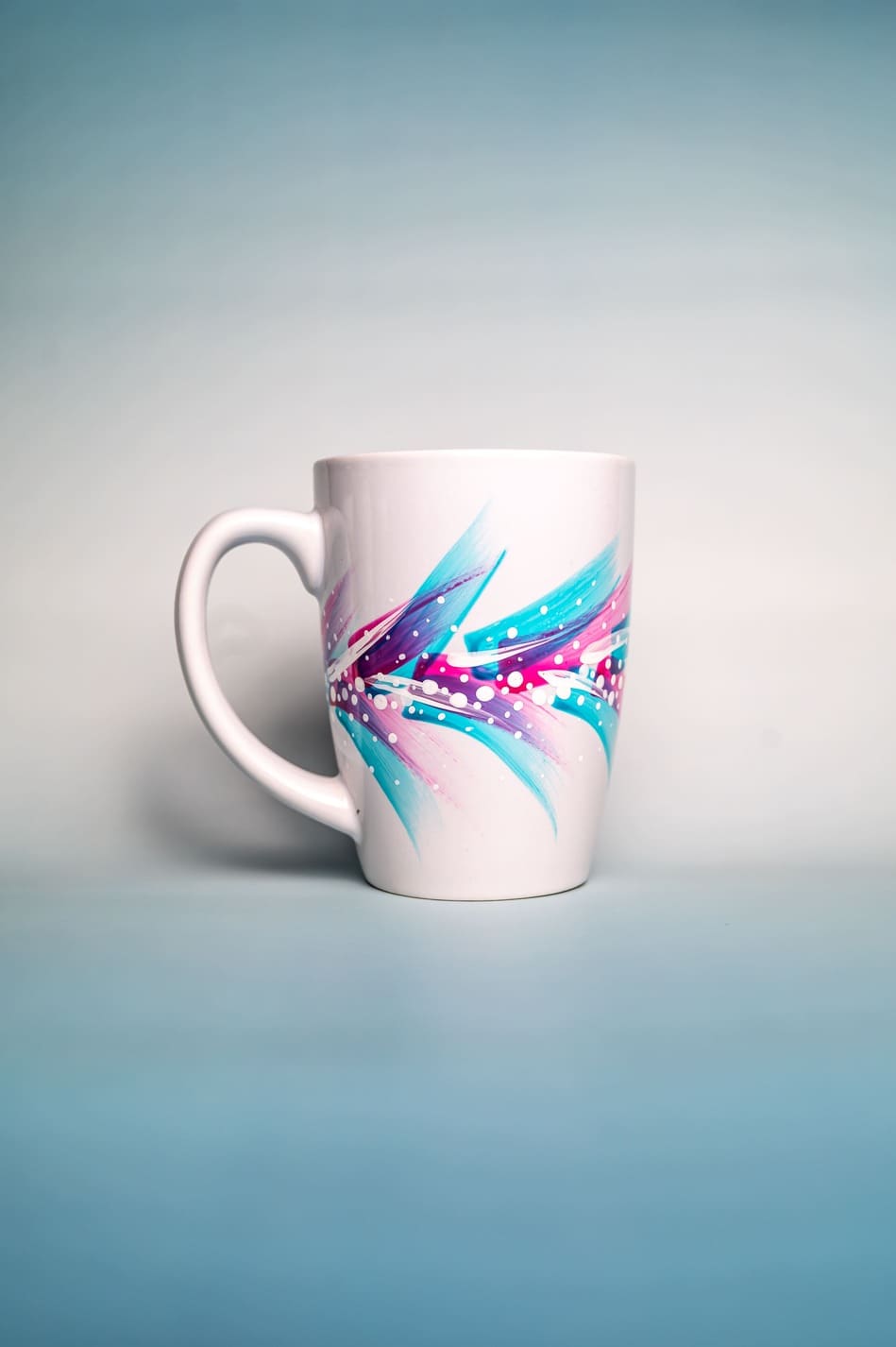 Ceramic mug with colorful motifs and flowing shapes